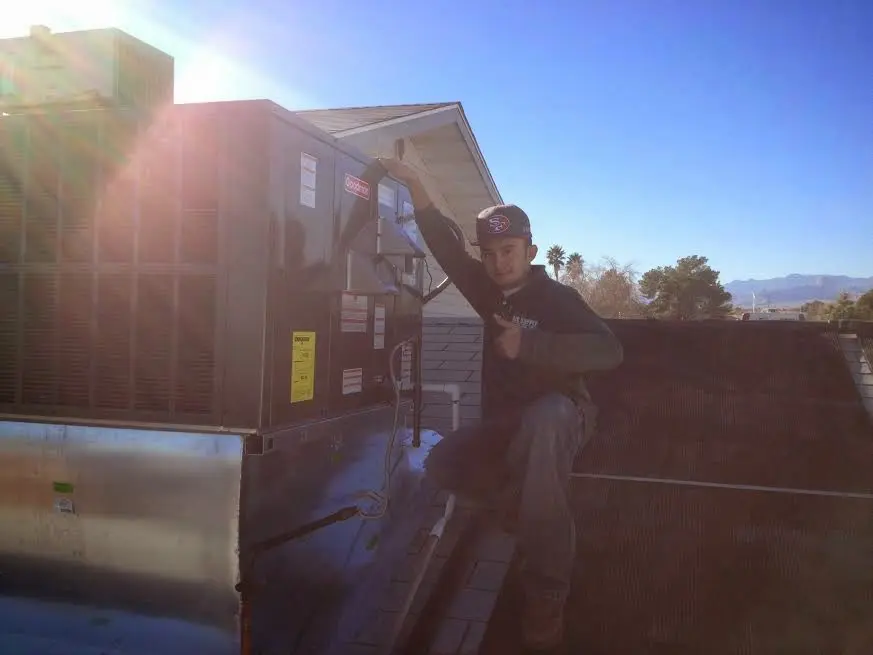 HVAC technician performing AC Tune-Up on a rooftop unit in Brookings